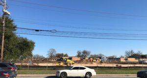 cars driving in front of a construction site