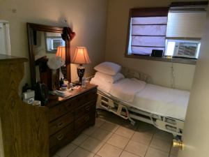 a room with a dresser and a hosptial bed