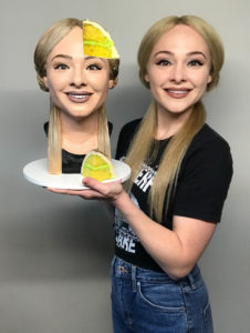 Cake artist Natalie Siderf poses next to her selfie cake &ndash;&nbsp;a realistic bust of her blonde head with one slice missing.