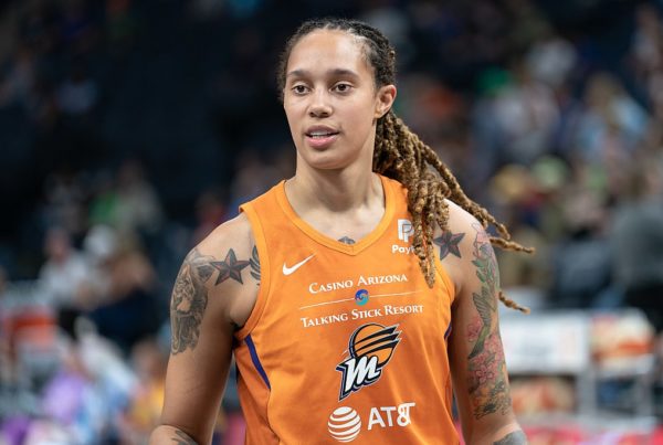 Brittney Griner on a basketball court in an orange jersey
