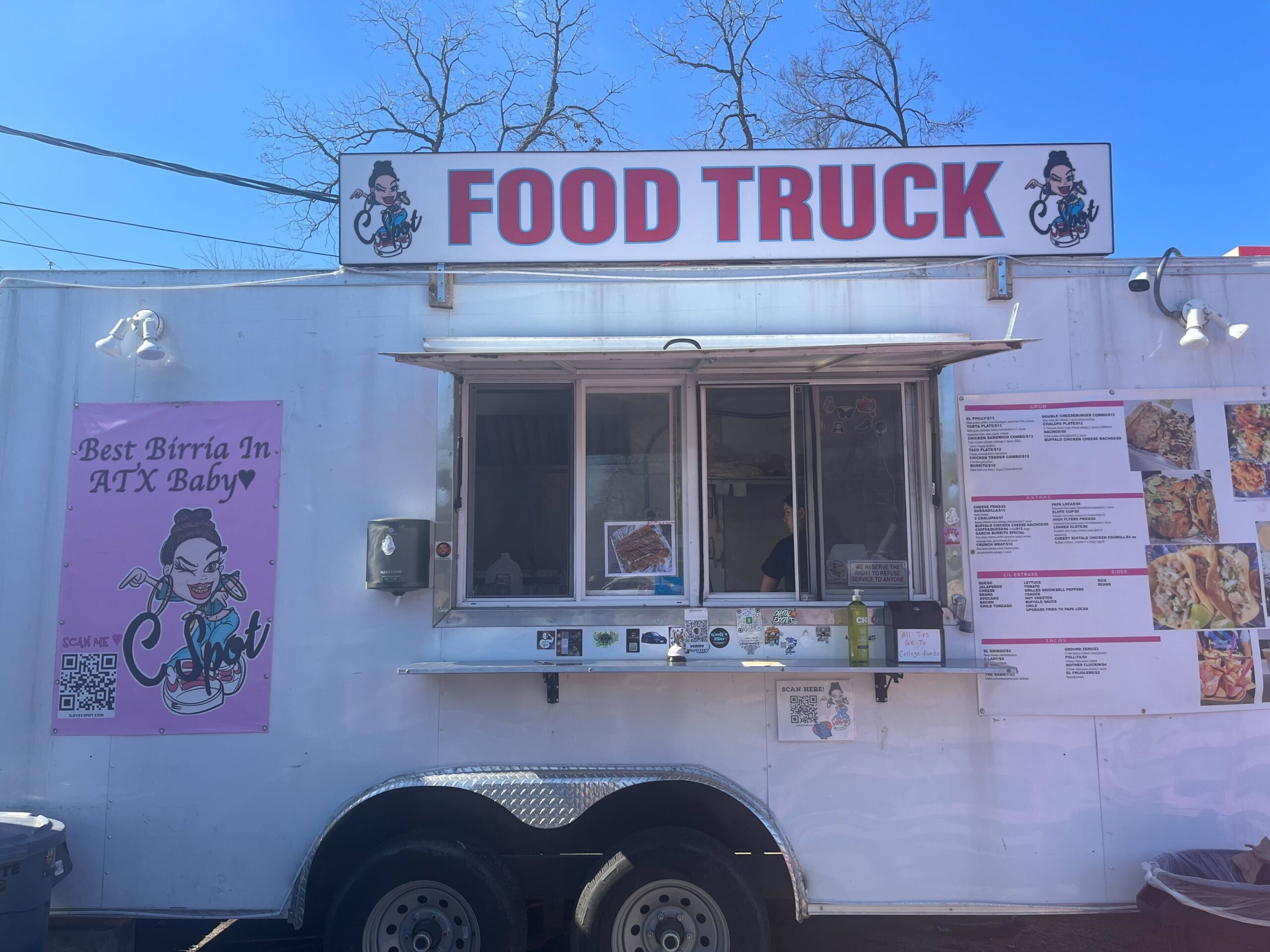The exterior of the Love C Spot food truck is seen facing the window. Above the window in big letters is a sign reading 