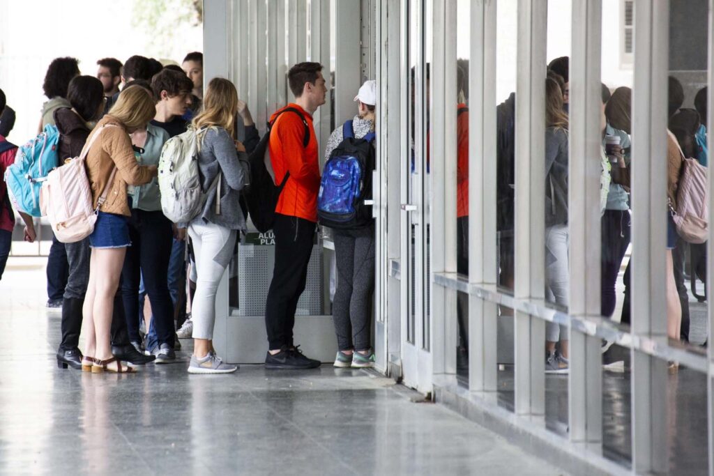 Students stand in a line stretching out the door to vote on the UT campus