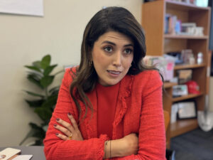 A woman dressed in red speaks to someone off to the side. This is Austin city council member Vanessa Fuentes.