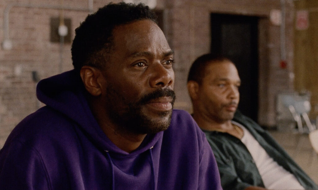 A still from the film "Sing Sing" shows two people with serious expressions.