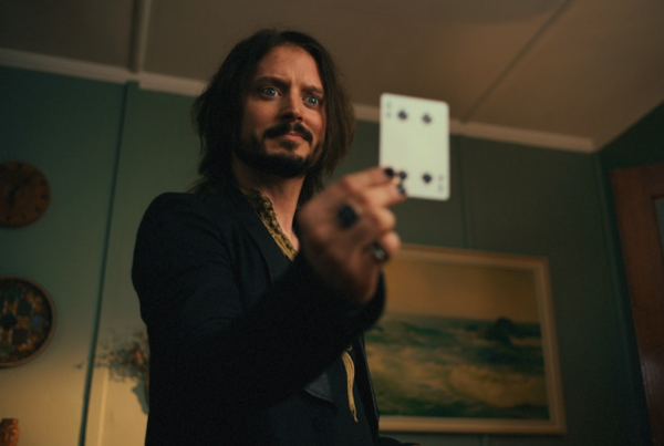 Actor Elijah Wood holds up a playing card in a screenshot from the film.