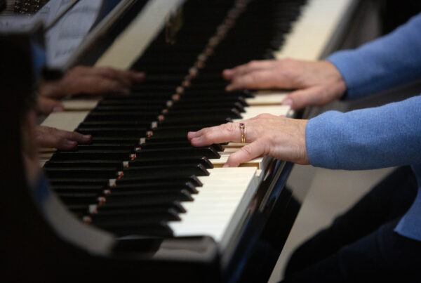 A closeup of hands on a piano