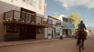 A person rides a horse down what looks like an old west street