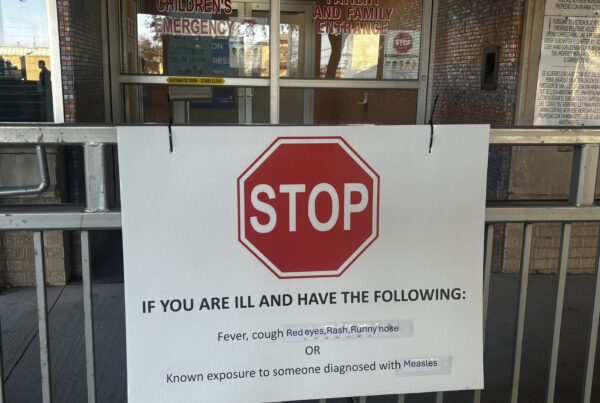 A sign outside a hospital advises patients to stop if they have had exposure to measles or if they have measles symptoms.