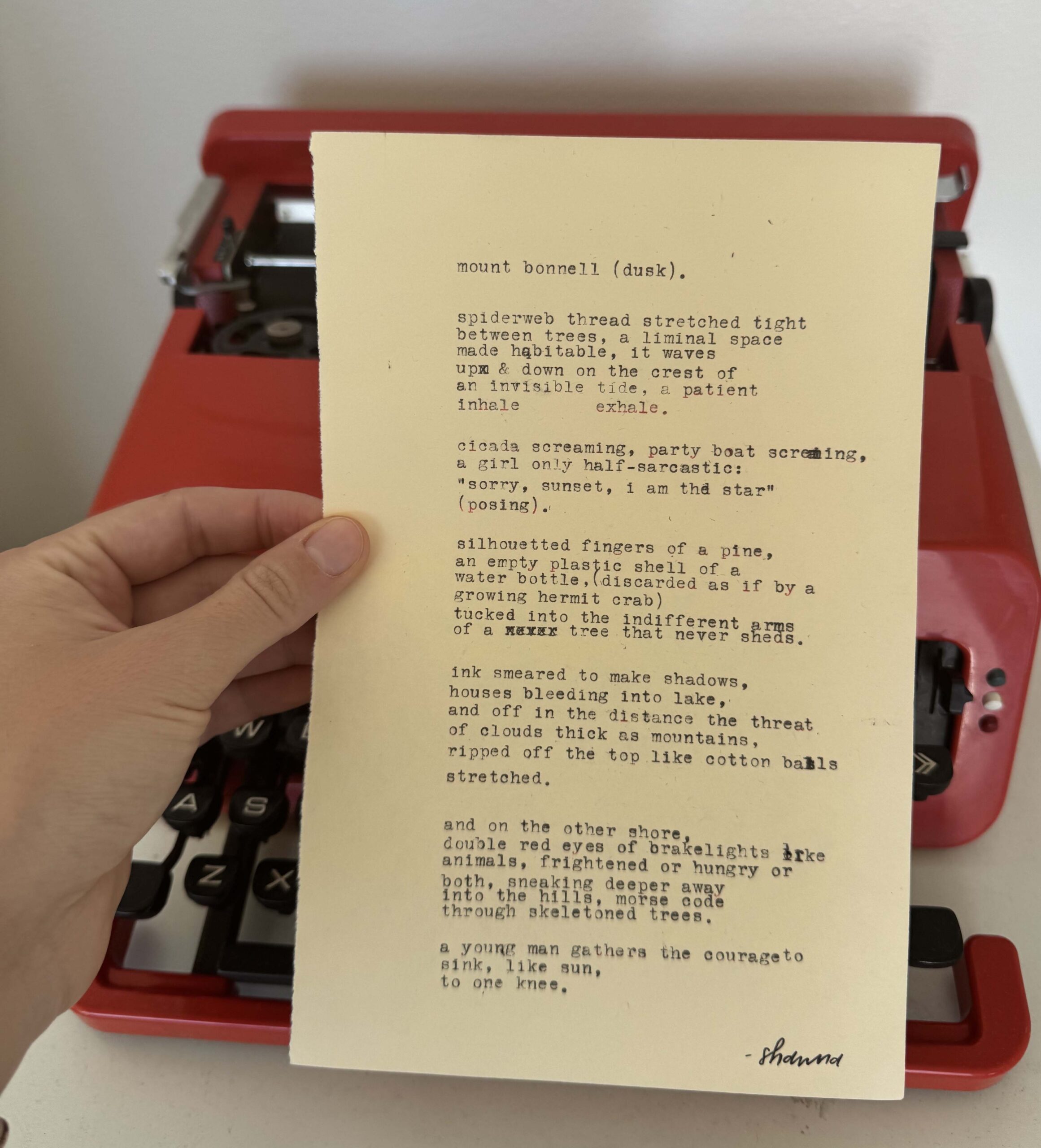 A photo of the typewritten poem on a torn half-sheet of light yellow paper.