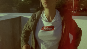 A person wears a t-shirt reading "sober"