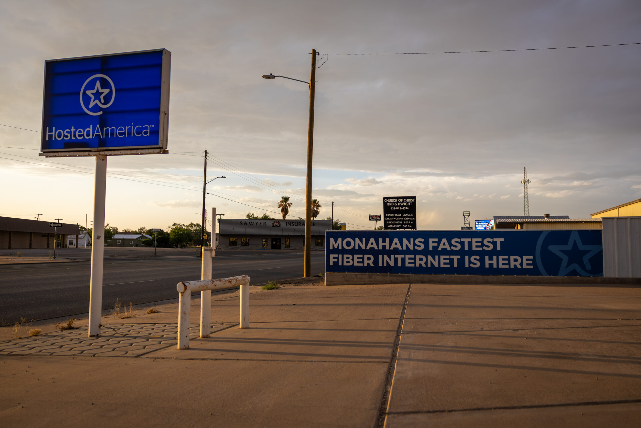 A sign set on a pole along a roadway reads 
