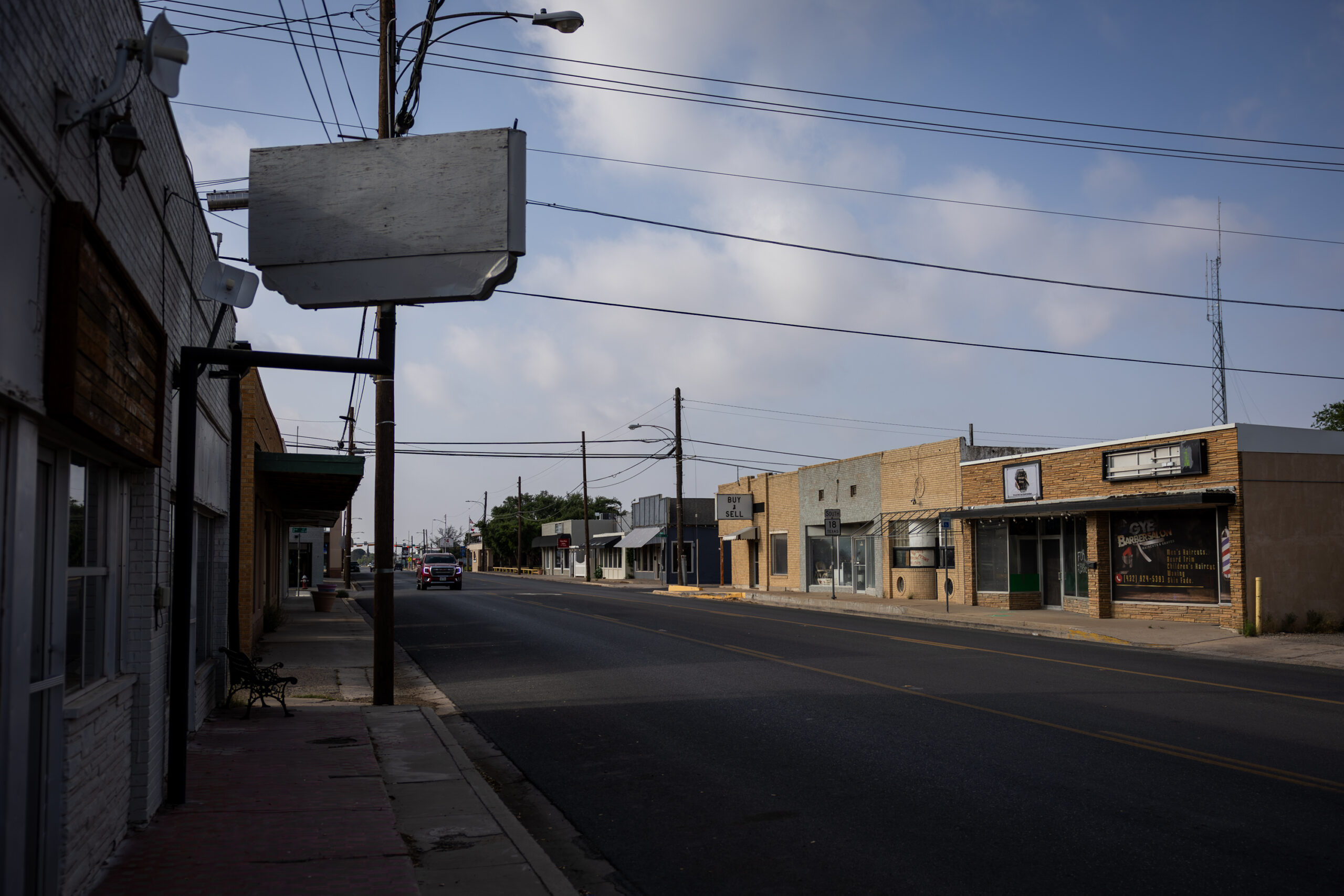 A quiet street lined with old buildings is seen.