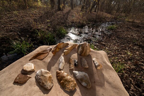 Stone artifacts sit on a stone ledge above a creek bed.