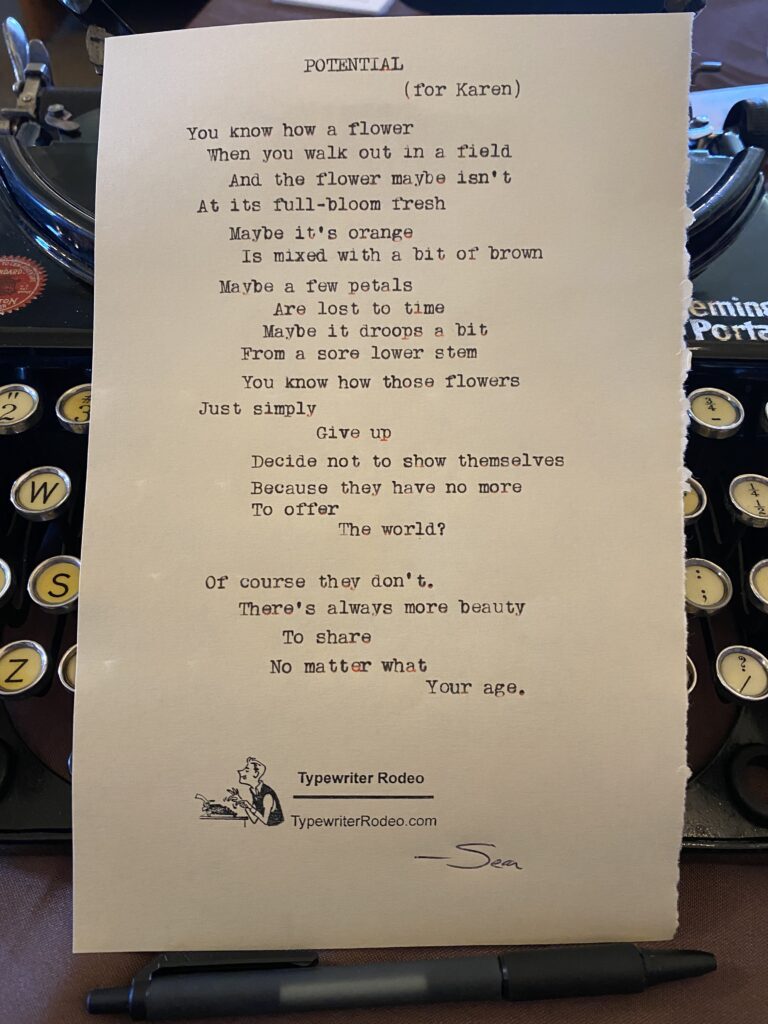 A photo of the typewritten poem on a torn half-sheet of light yellow paper.