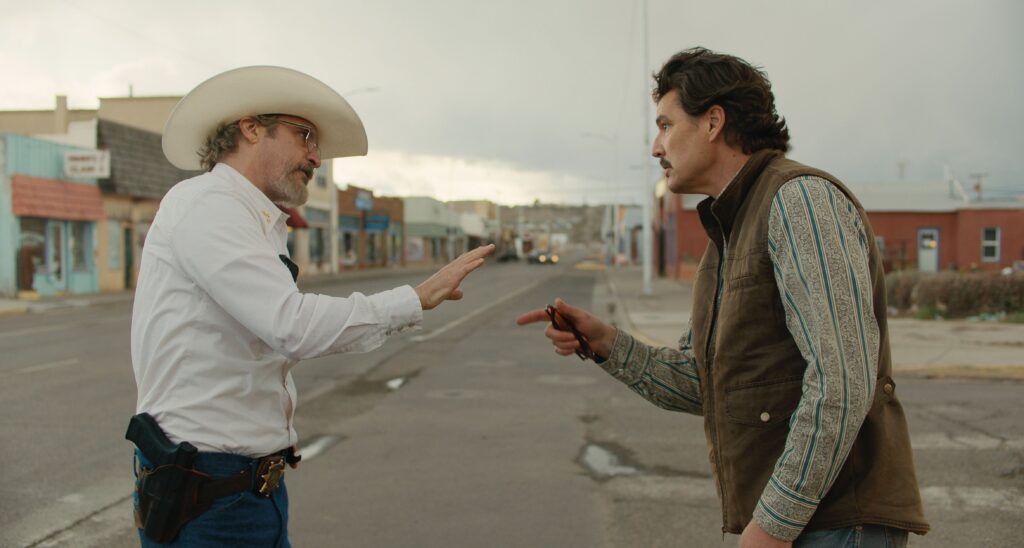 A still image from the film shows the two actors in a confrontation in a small city street.