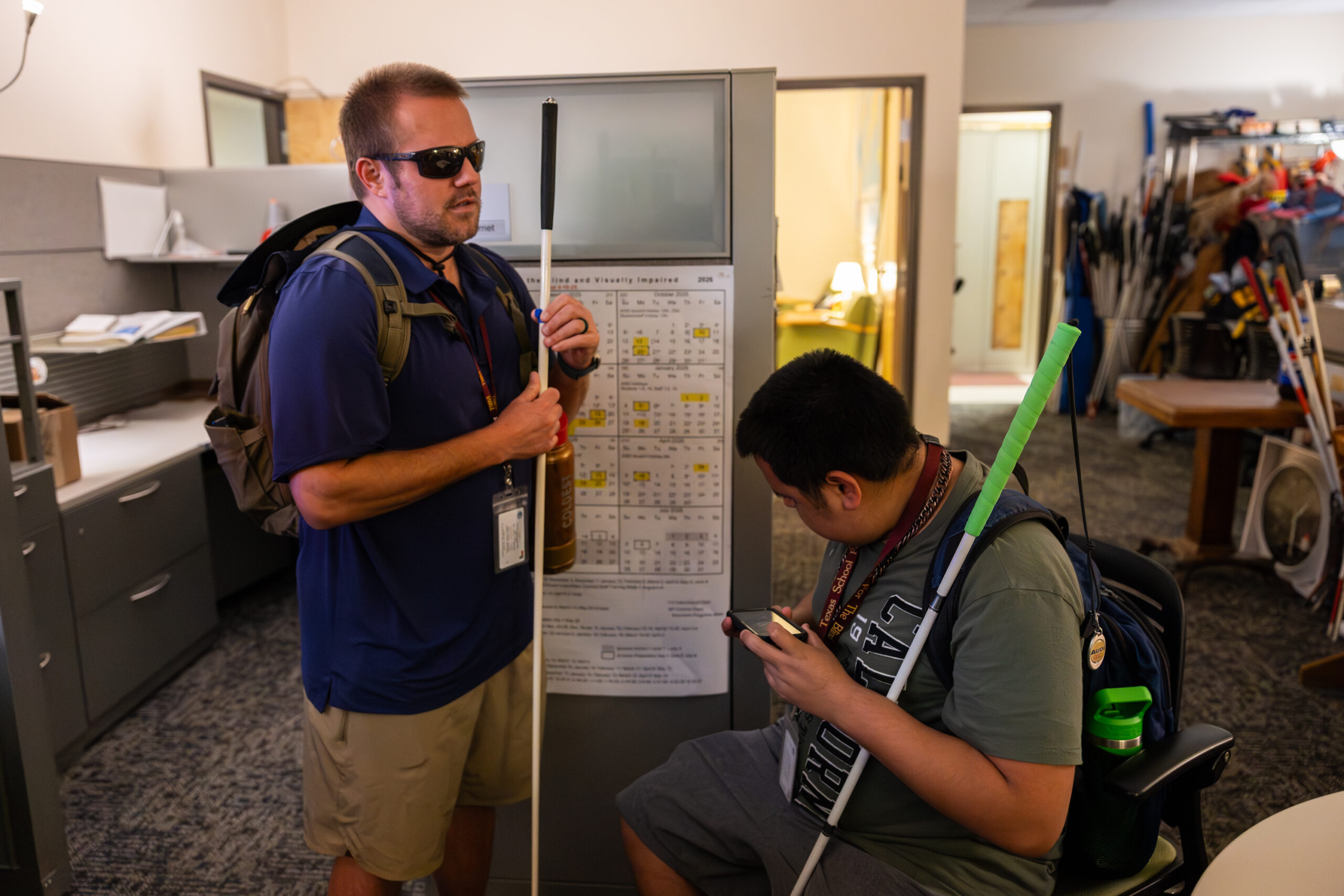 Two men speak to each other, both holding white canes. This is Drew Bernet and Oscar Garcia.