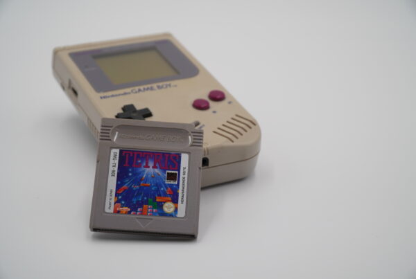 A Nintendo Game Boy with a Tetris game cartridge leaned against it.