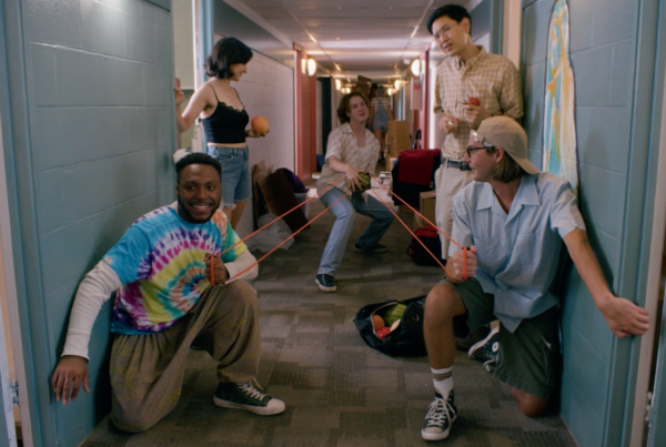 A photo of a group of college-aged people in what looks like a dorm hallway with a large sling shot.