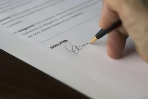 A closeup of a hand signing a document