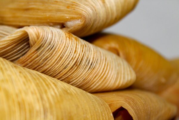 A close-up of a stack of tamales in corn husks