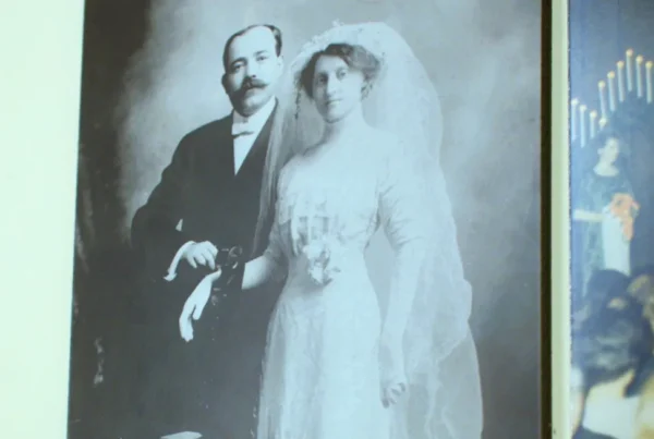 A black and white photo of two people dressed in wedding attire.
