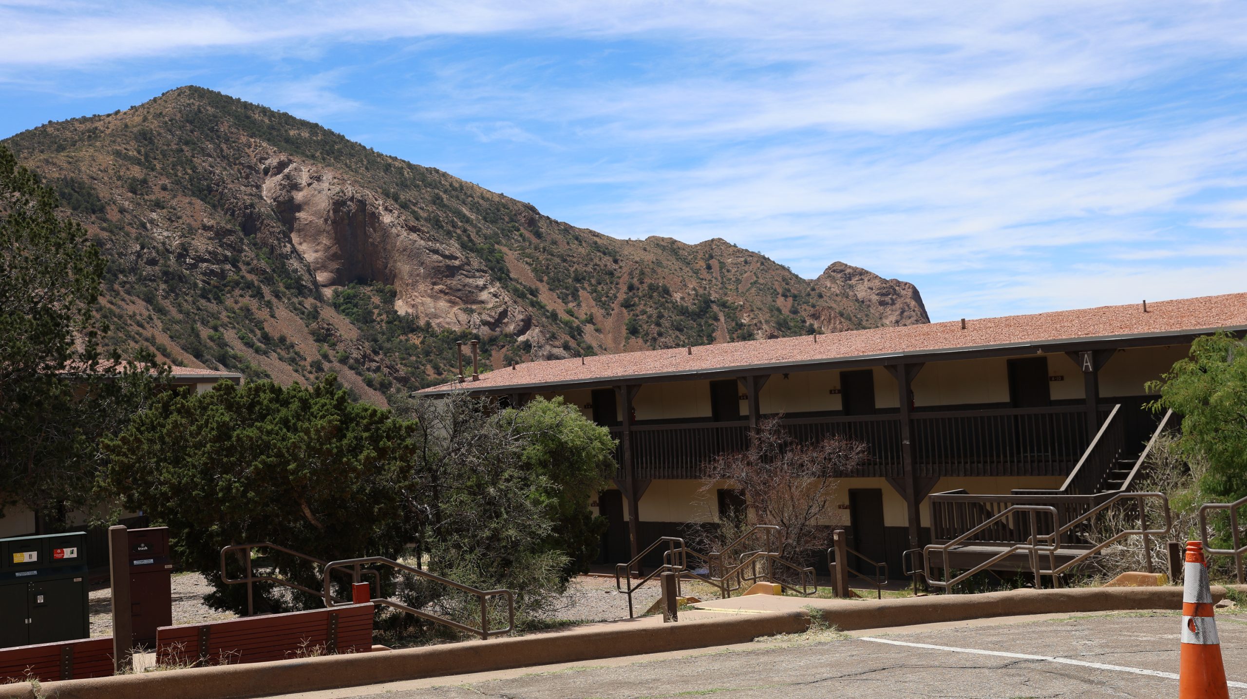 The exterior of a building is seen with a mountain in the background.
