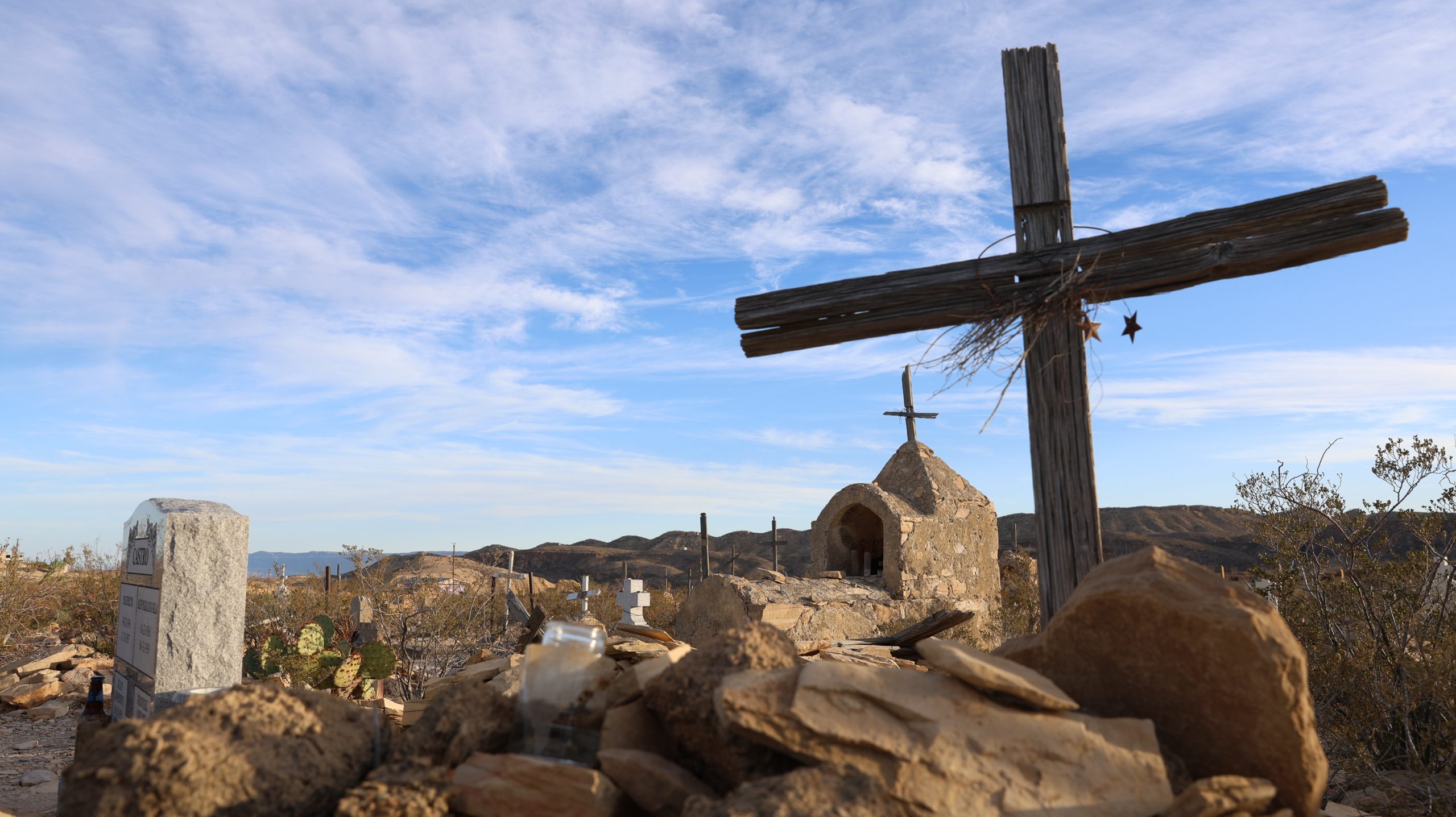 A cemetery, with prominent wooden crosses, is seen.