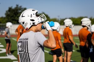 A student rehydrates during football practice on Aug. 22, 2024, at Westwood High School.