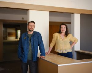 Two people stand and smile at the camera.
