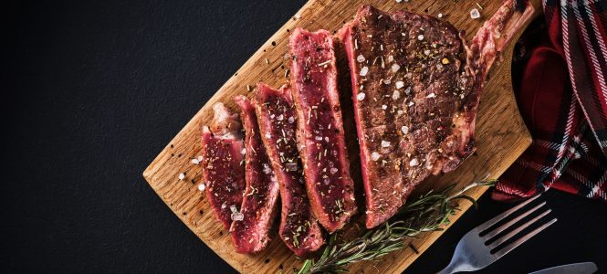 Grilled Bone-In Rib Eye with Garlicky Harissa – Christmas Grilling Series Entrecote. Steak on the bone. Rib eye. Tomahawk steak on the on a cutting board with rosemary. Roasting - Rare.