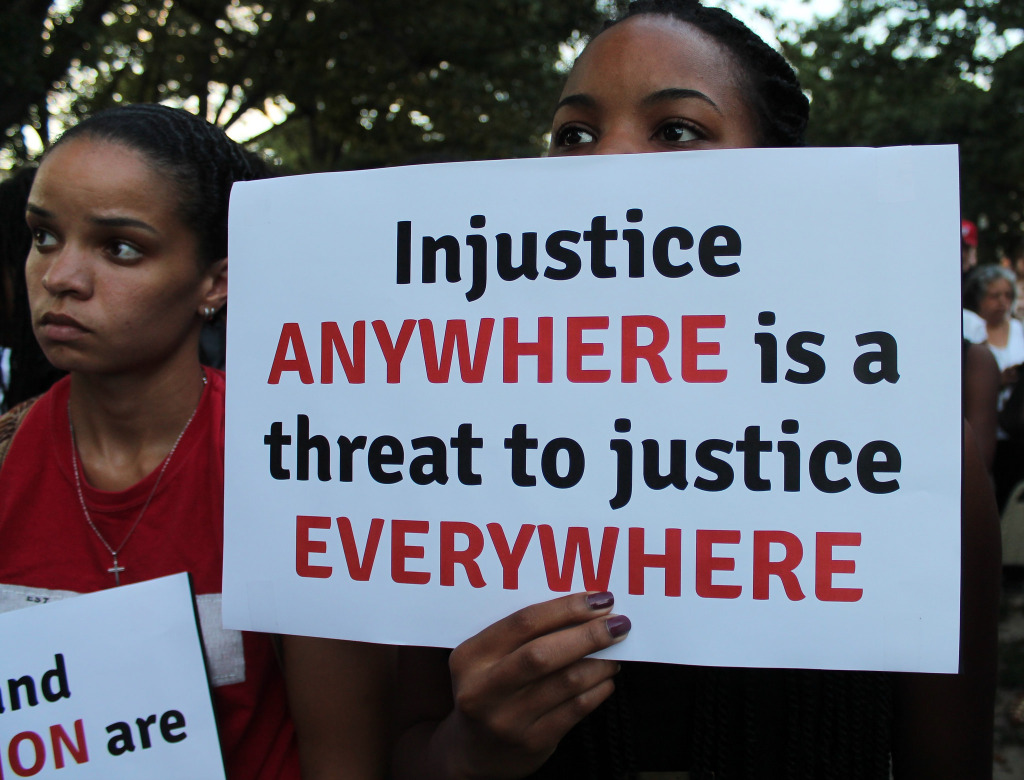 A protester holds a sign at a moment of silence for Michael Brown at Meridian Hill Park in D.C. in August.