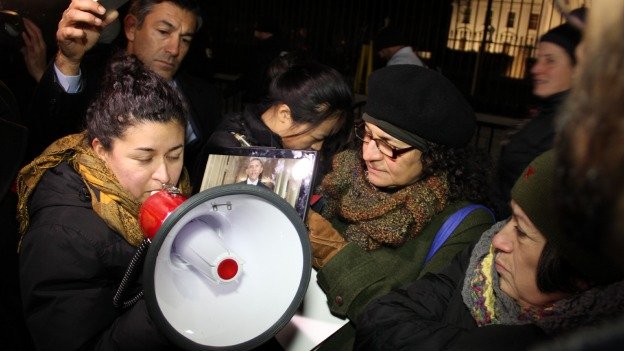 Immigration activists listen to President Barack Obama's speech on an iPad outside the White House as a translator provided details on the immigration plan being unveiled on Nov. 20, 2014. 