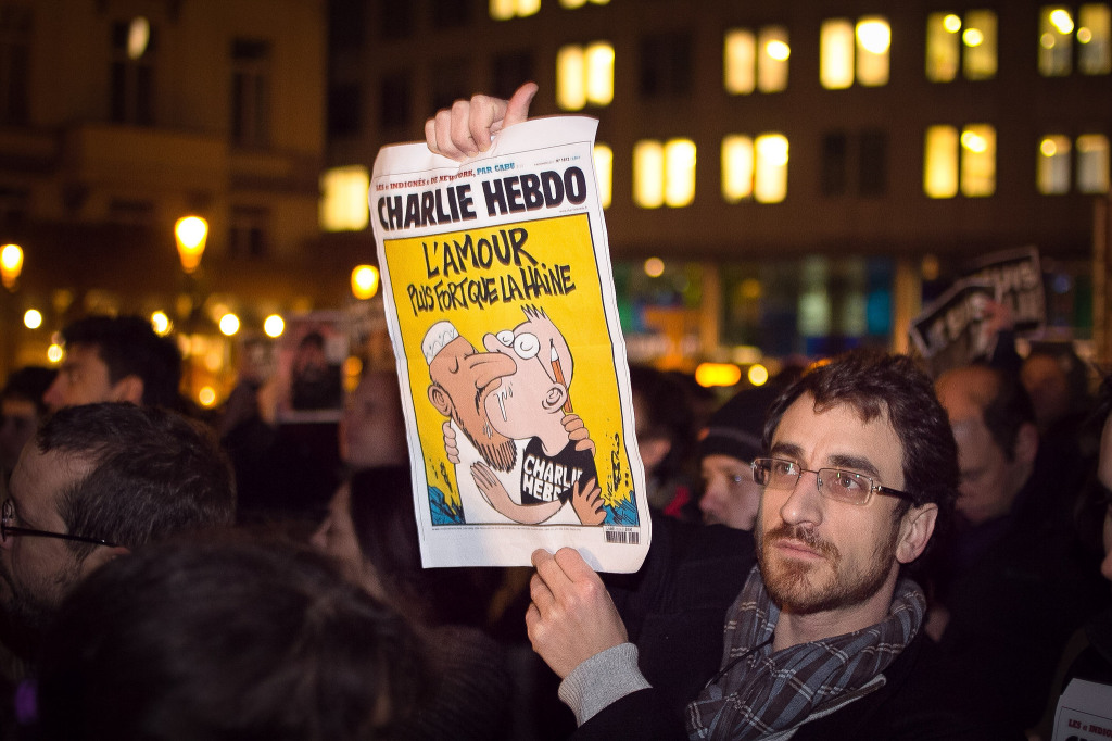 A supporter of Charlie Hebdo holds up a copy of the magazine Wednesday at a rally in Brussels.