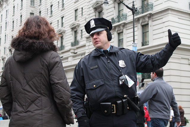 A Metropolitan Police Officer directs pedestrians near 14th St NW in Washington, D.C.