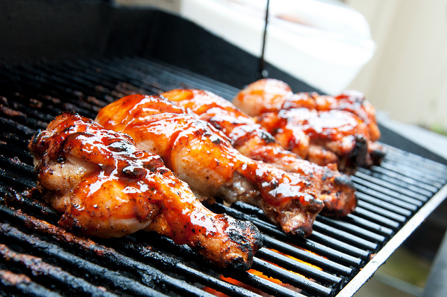 Barbecue chicken drumsticks on a grill.