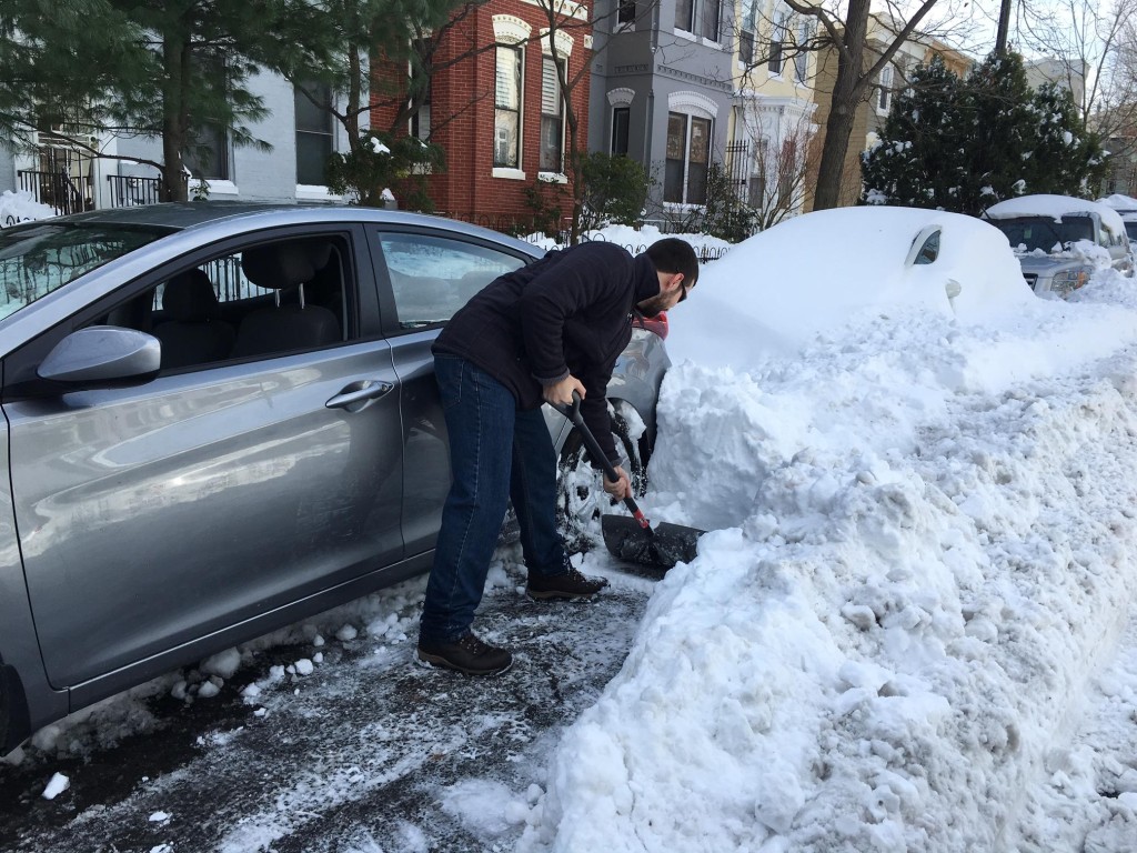 A D.C. resident shovels his car out of the snow.