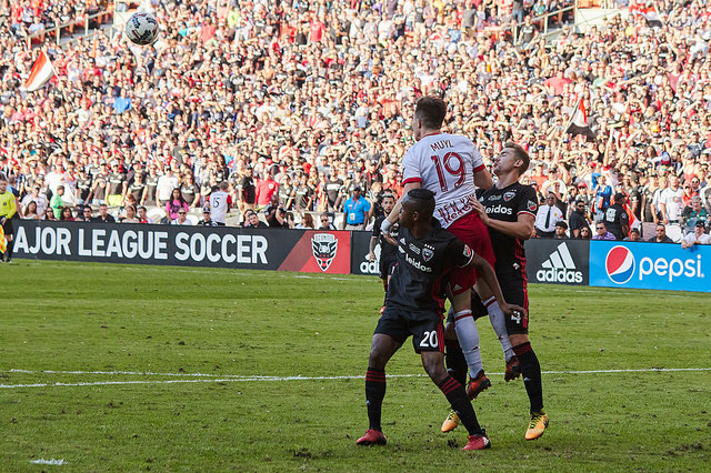 D.C. United players Jalen Robinson (left) and Russell Canouse (right) jostle for position with New York Red Bulls midfielder Alex Muyl in a match at RFK Stadium on October 22, 2017. 