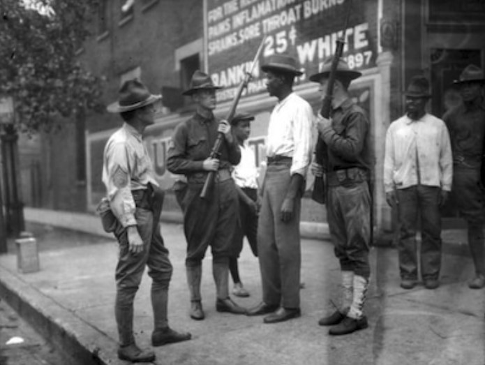 Three armed soldiers question an unidentified African American man in D.C. during the 1919 race riots.