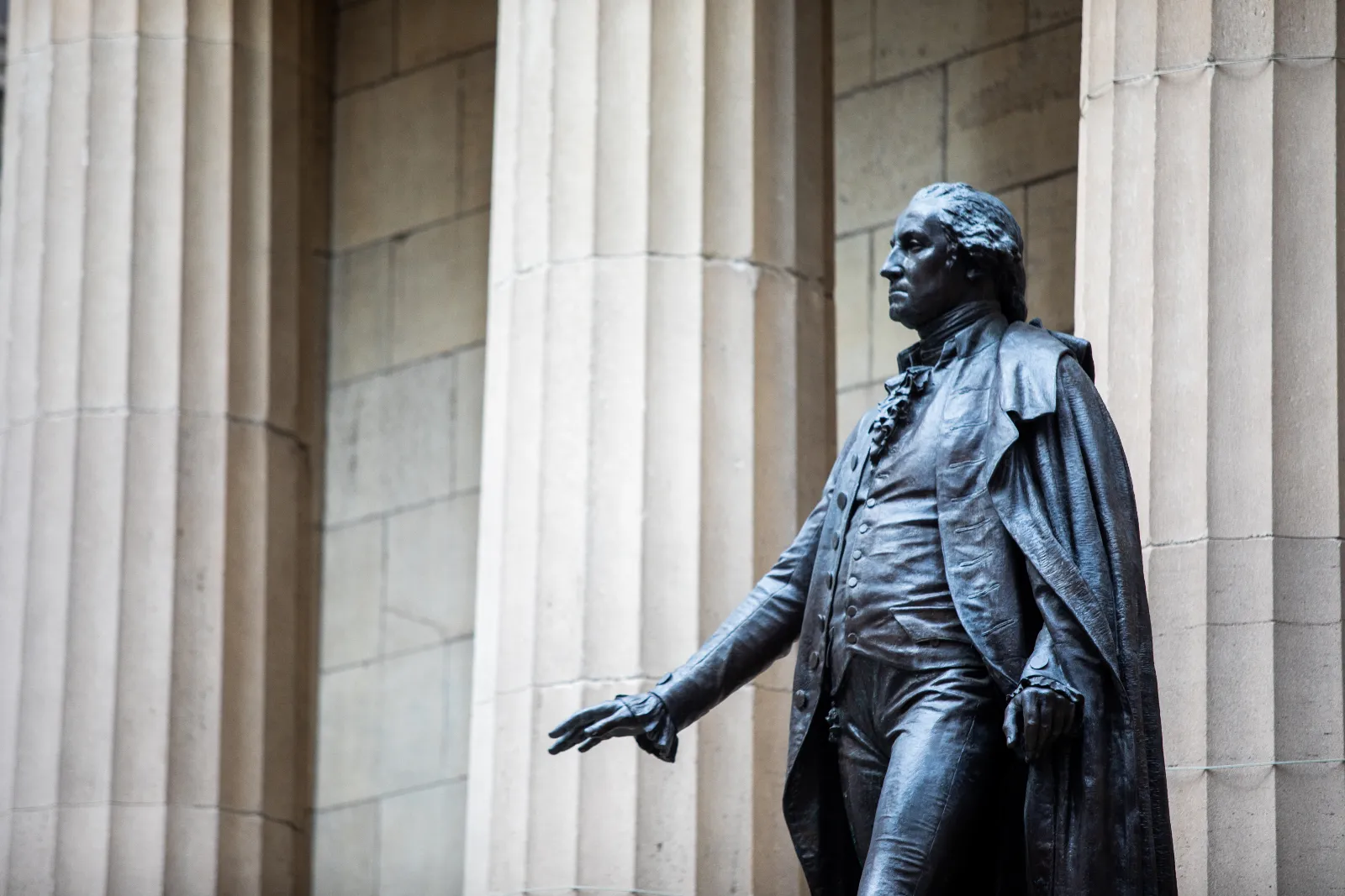 A statue of a man in front of a building with columns