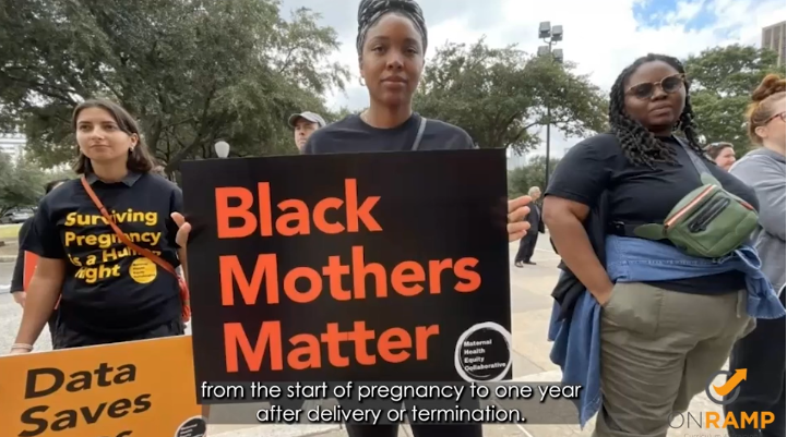 Woman holding up a sign that says Black Mothers Matter