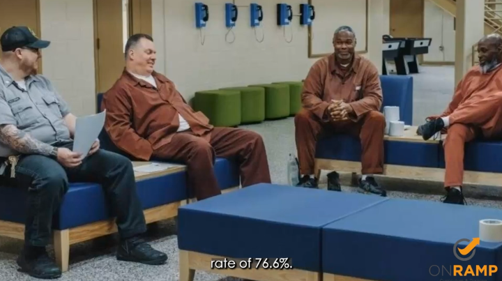 3 incarcerated man and an officer sitting together, smiling. 