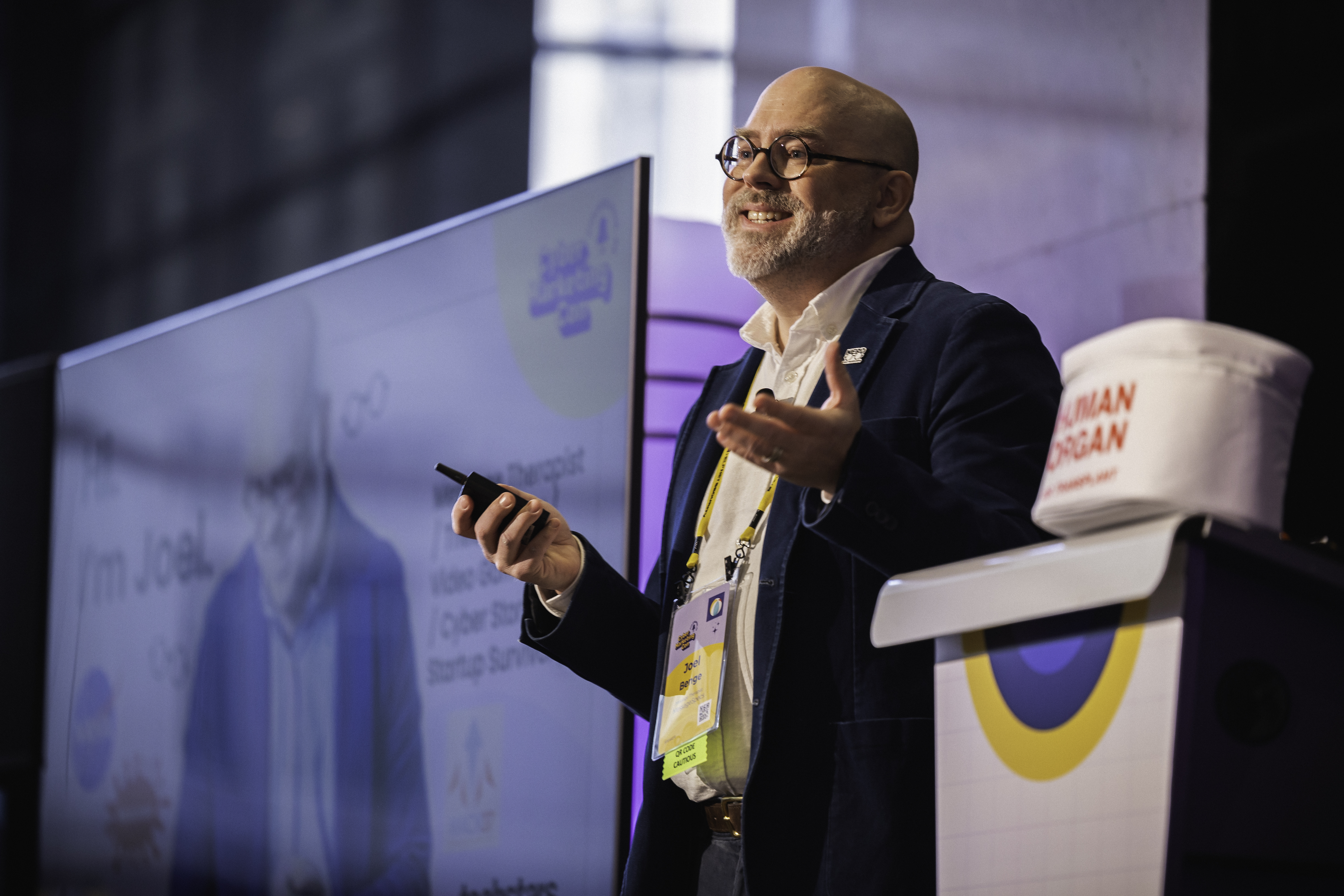 Joel standing on stage with a presentation remote in his hand.
