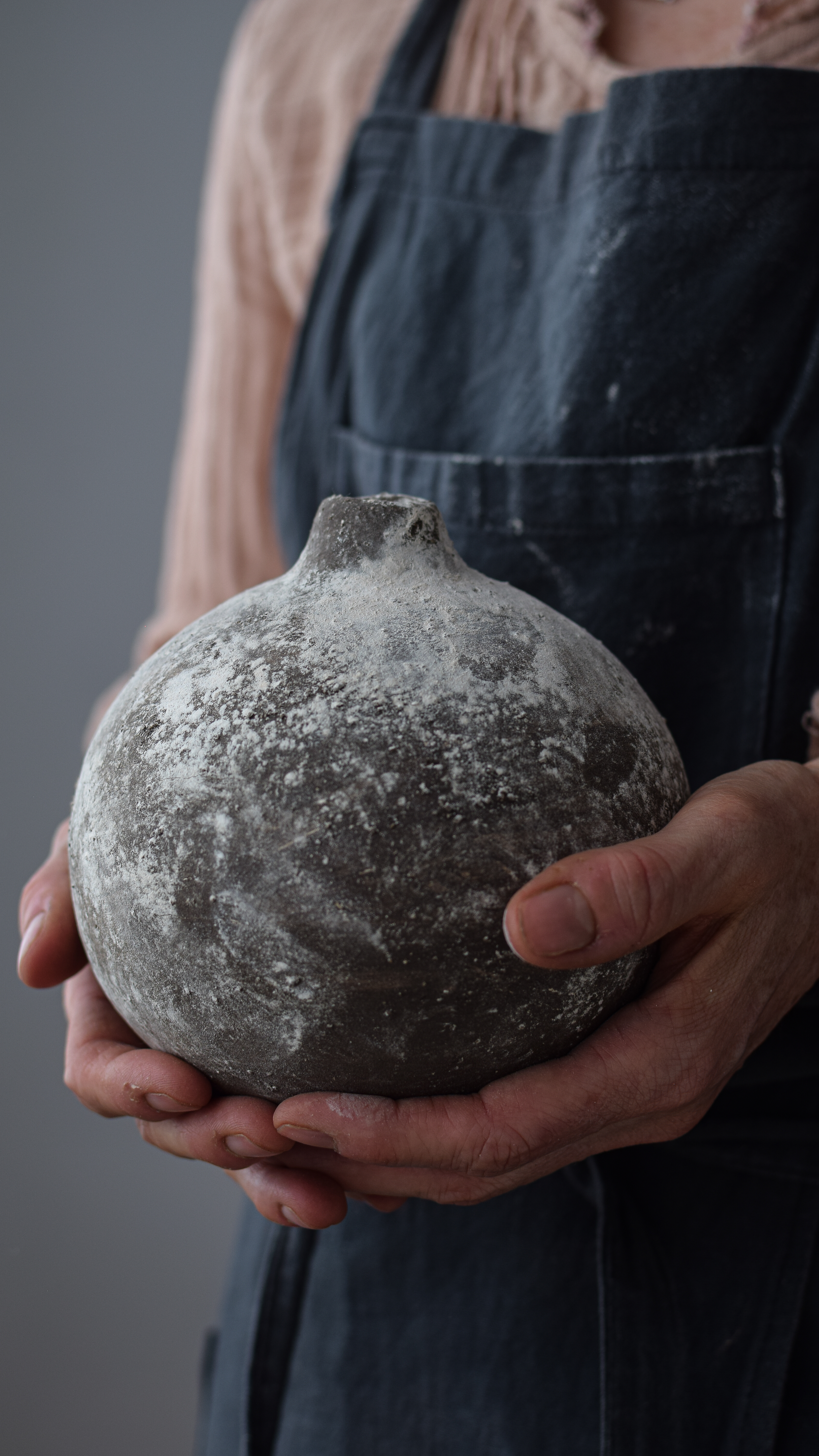 Handcrafted stoneware bottle in a warm bone color with a unique textured surface. Perfect for adding a touch of rustic elegance to your home decor