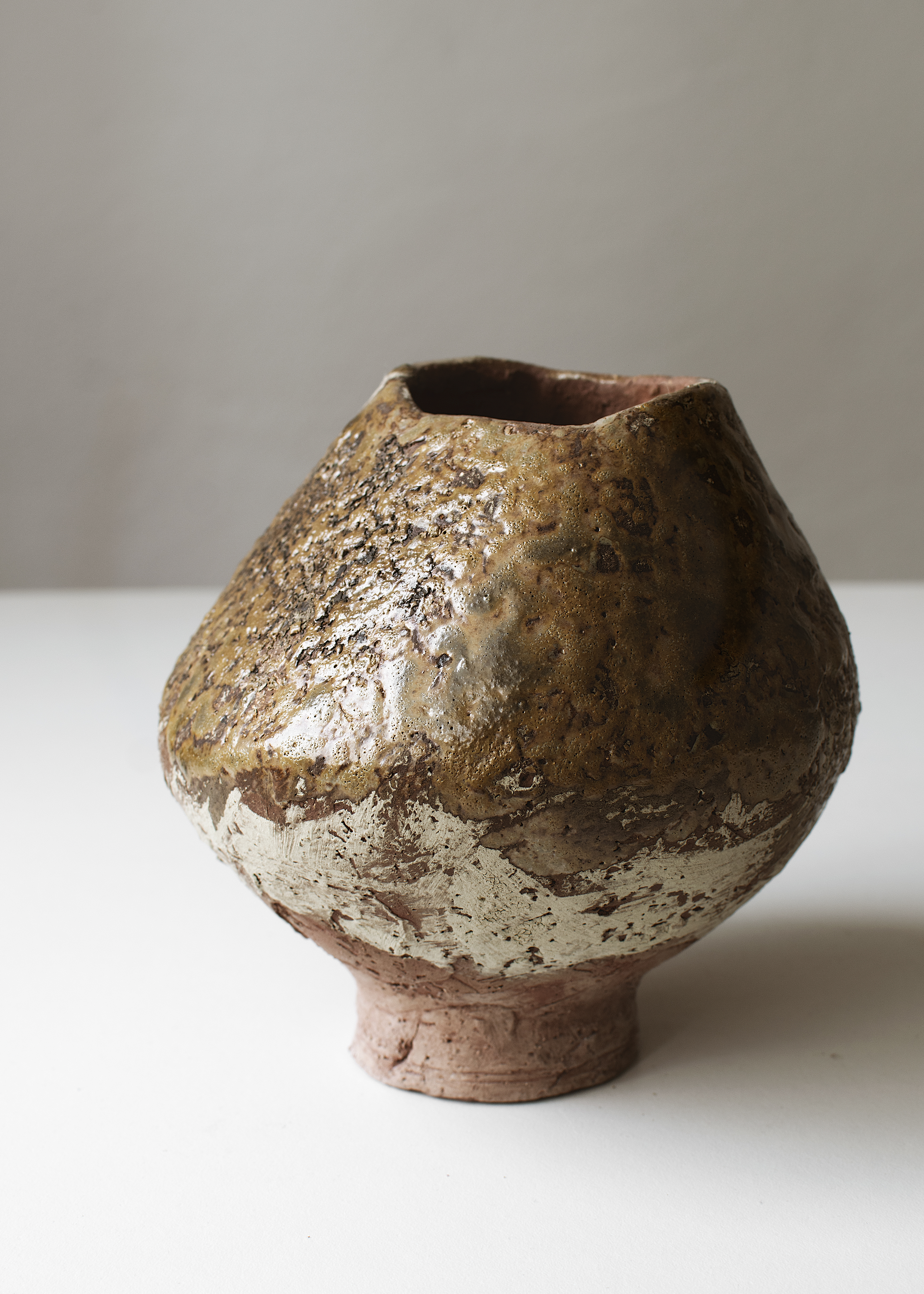 Handcrafted stoneware bottle in a warm bone color with a unique textured surface. Perfect for adding a touch of rustic elegance to your home decor