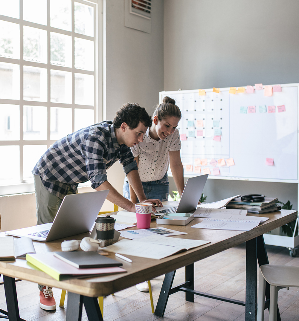 Smiling young woman employee thinking about creating additional sources of income