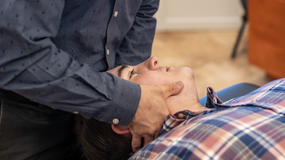 Physical therapist assessing a patient's jaw mobility during TMD evaluation
