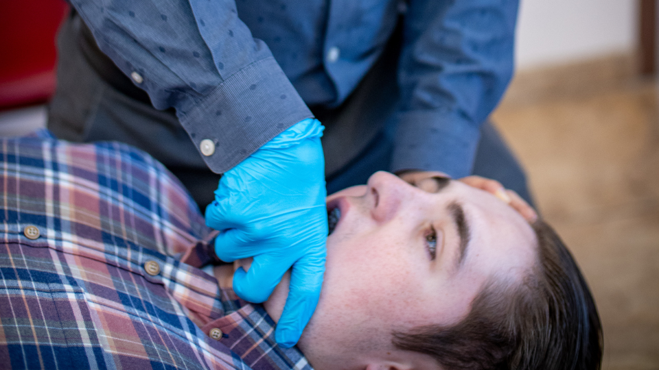 Physical therapist performing an oral examination on a patient with TMD
