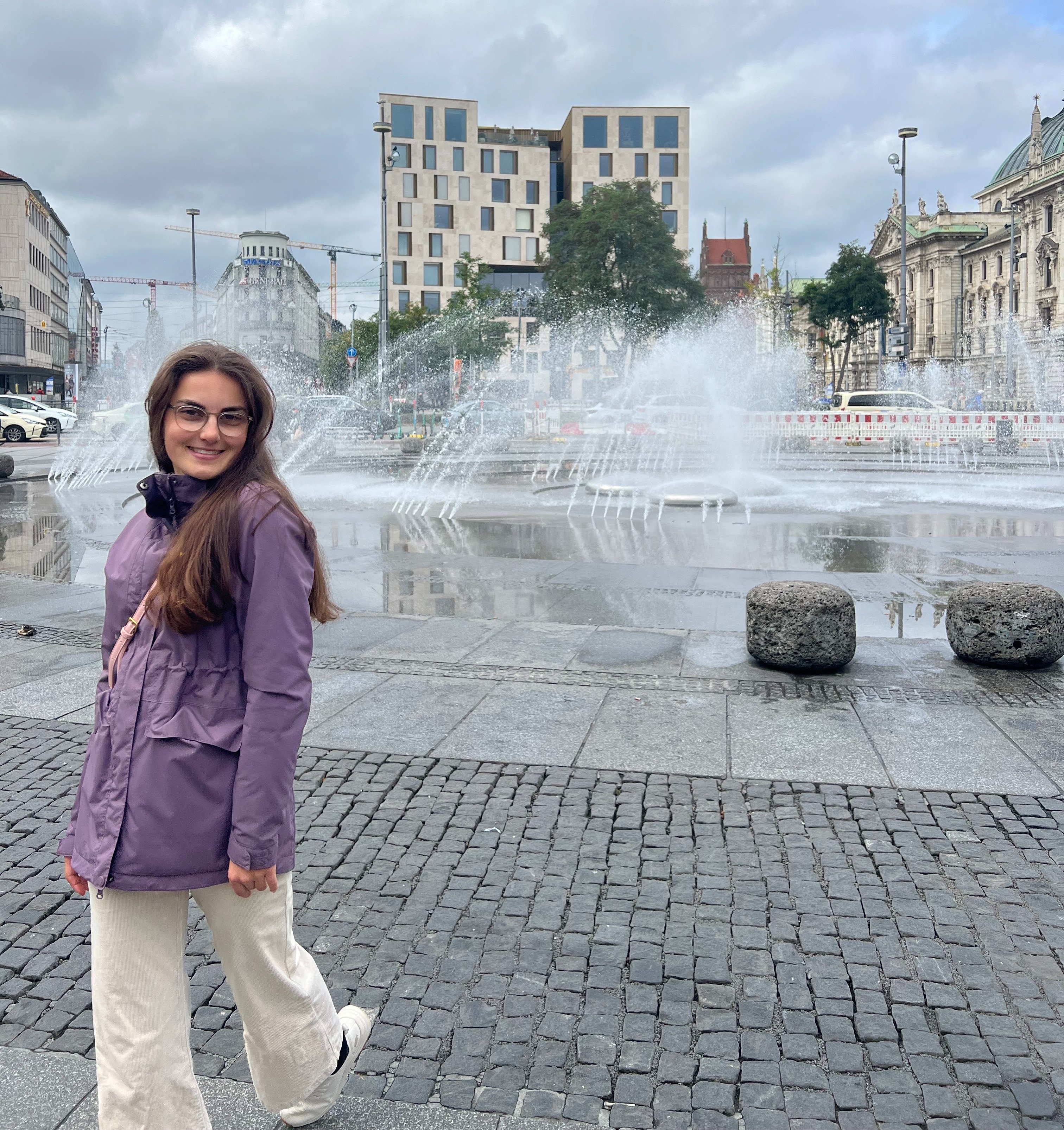 young adult female standing in front of fountain