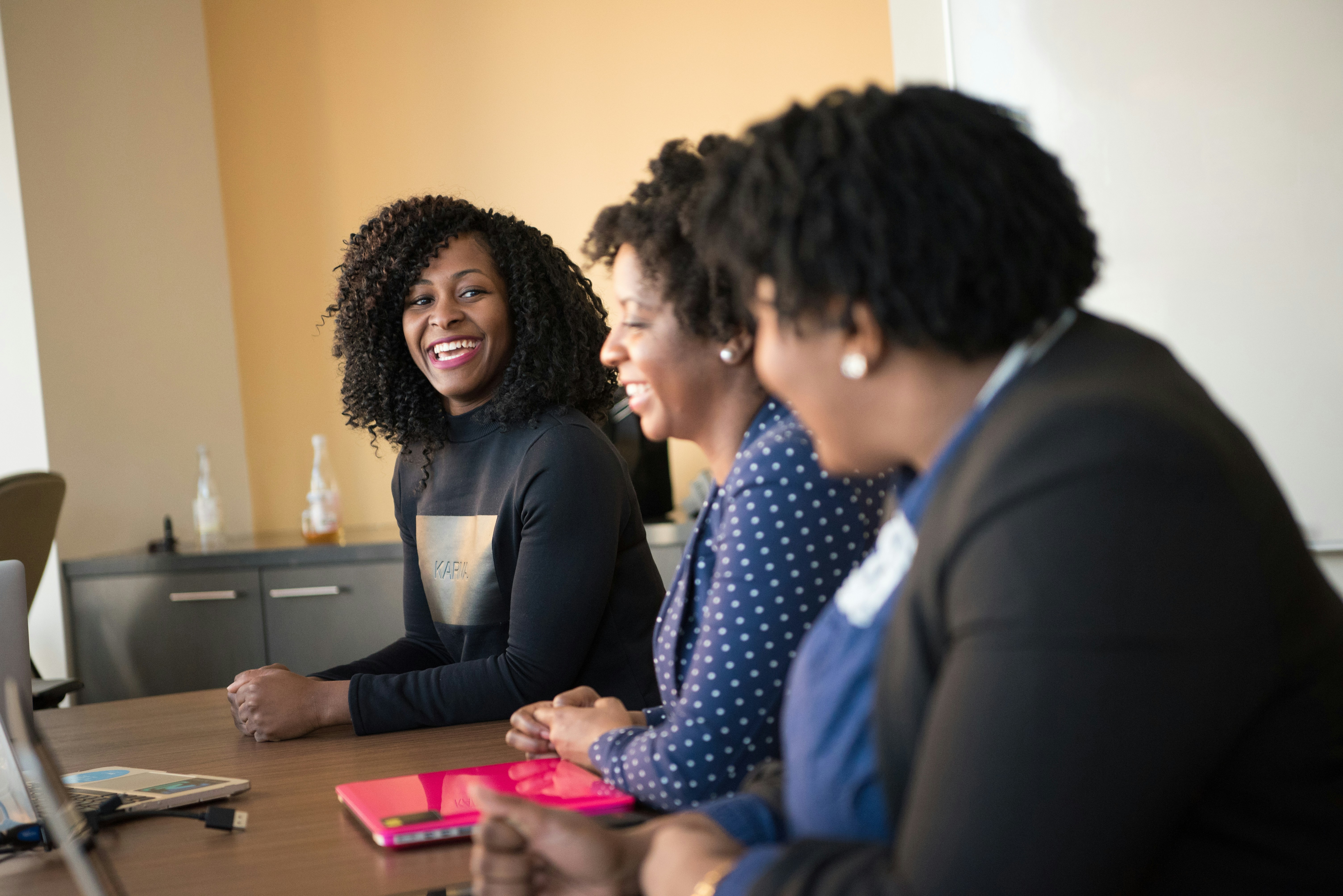 Three people talking at a table, illustrating awareness and intentional reflection on priorities.