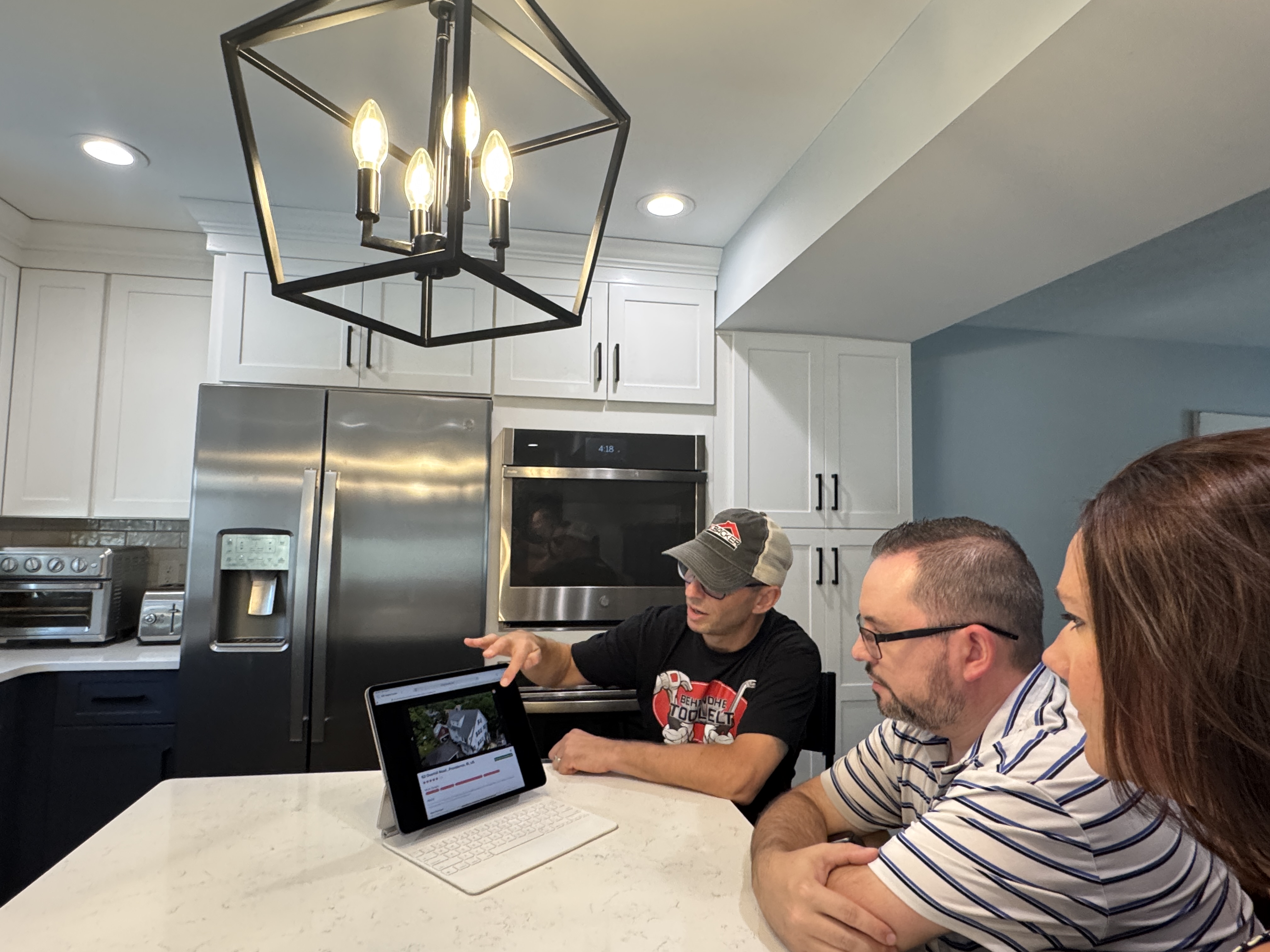 This image is a contractor sales person showing homeowners at a kitchen table Project Map it